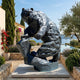 Monumental Rearing Grizzly Bear Bronze Sculpture by Giant Sculptures, 320cm, displayed on a stone terrace with olive trees and a sea view beyond.