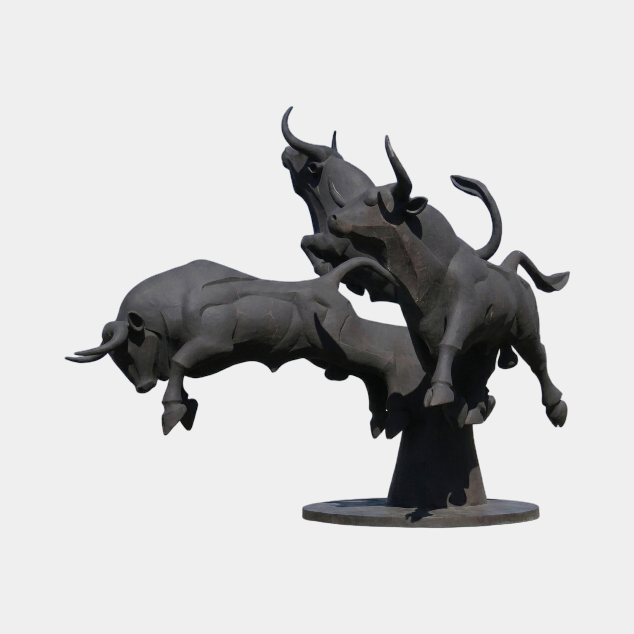 Monumental Three Charging Bulls Bronze Sculpture by Giant Sculptures, 450cm, dark patina bulls mid-leap on a rocky mound base against a plain background.