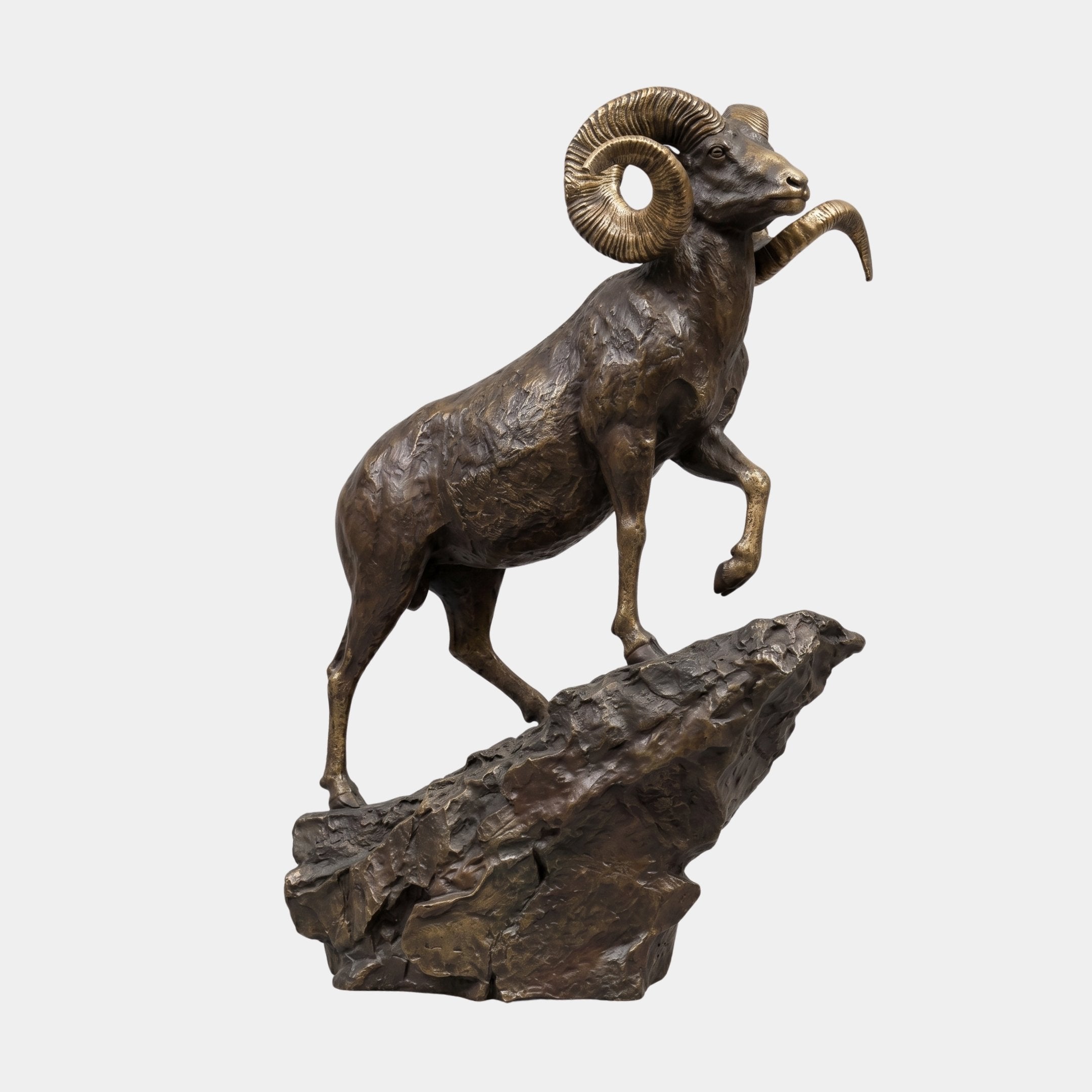 Monumental Traditional Bighorn Ram Bronze Sculpture by Giant Sculptures, rearing on a jagged rock base with curled golden horns and dark brown patina.
