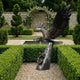Monumental Traditional Eagle Bronze Sculpture by Giant Sculptures with wings raised on a tree-trunk column with coiled snake, set in a formal hedged garden.