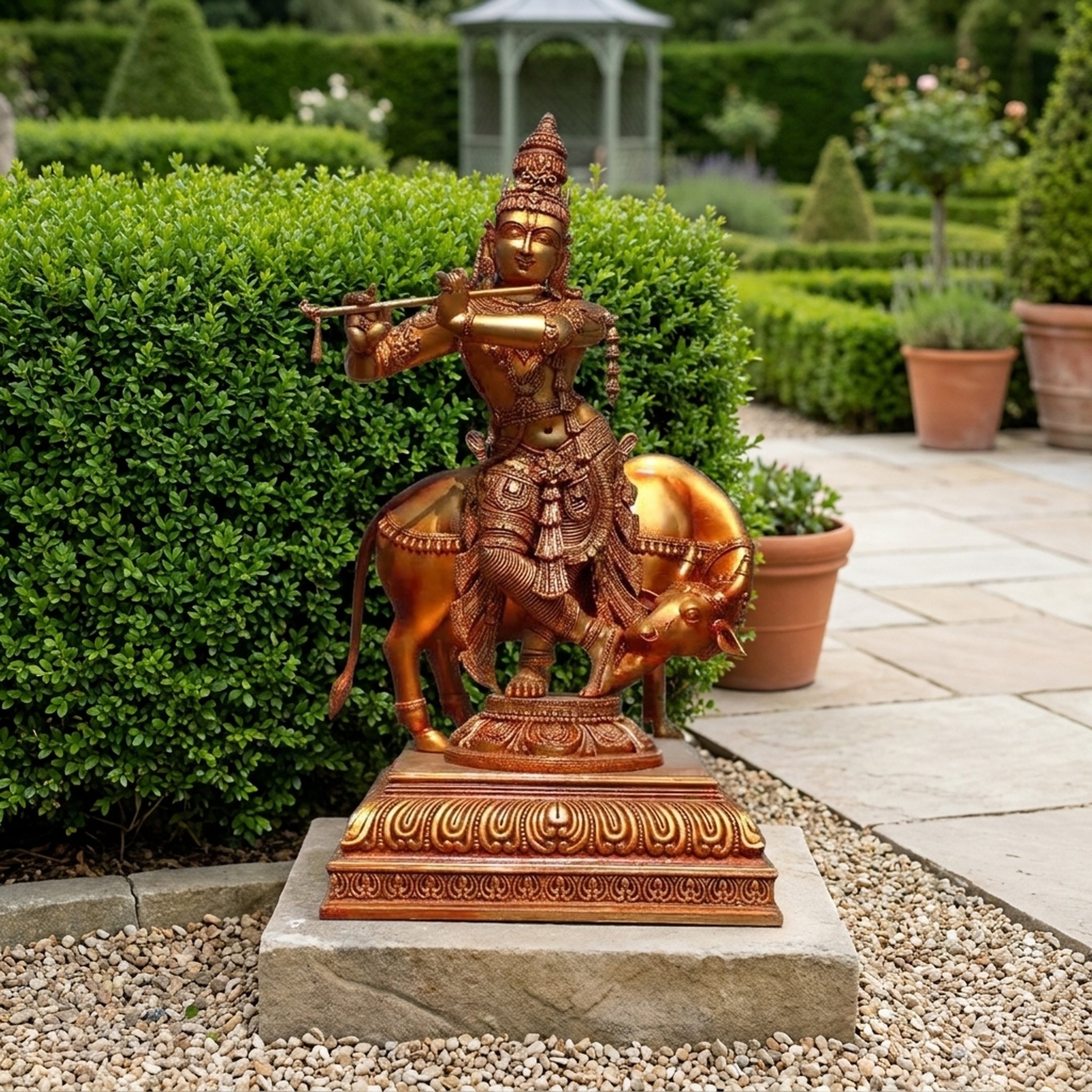 Monumental Traditional Krishna and Sacred Cow Bronze Sculpture by Giant Sculptures, golden figure playing flute beside cow on tiered plinth in garden.