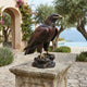 Monumental Traditional Landing Eagle Bronze Sculpture by Giant Sculptures with dark patina and gold talons, displayed on a stone plinth overlooking the sea.
