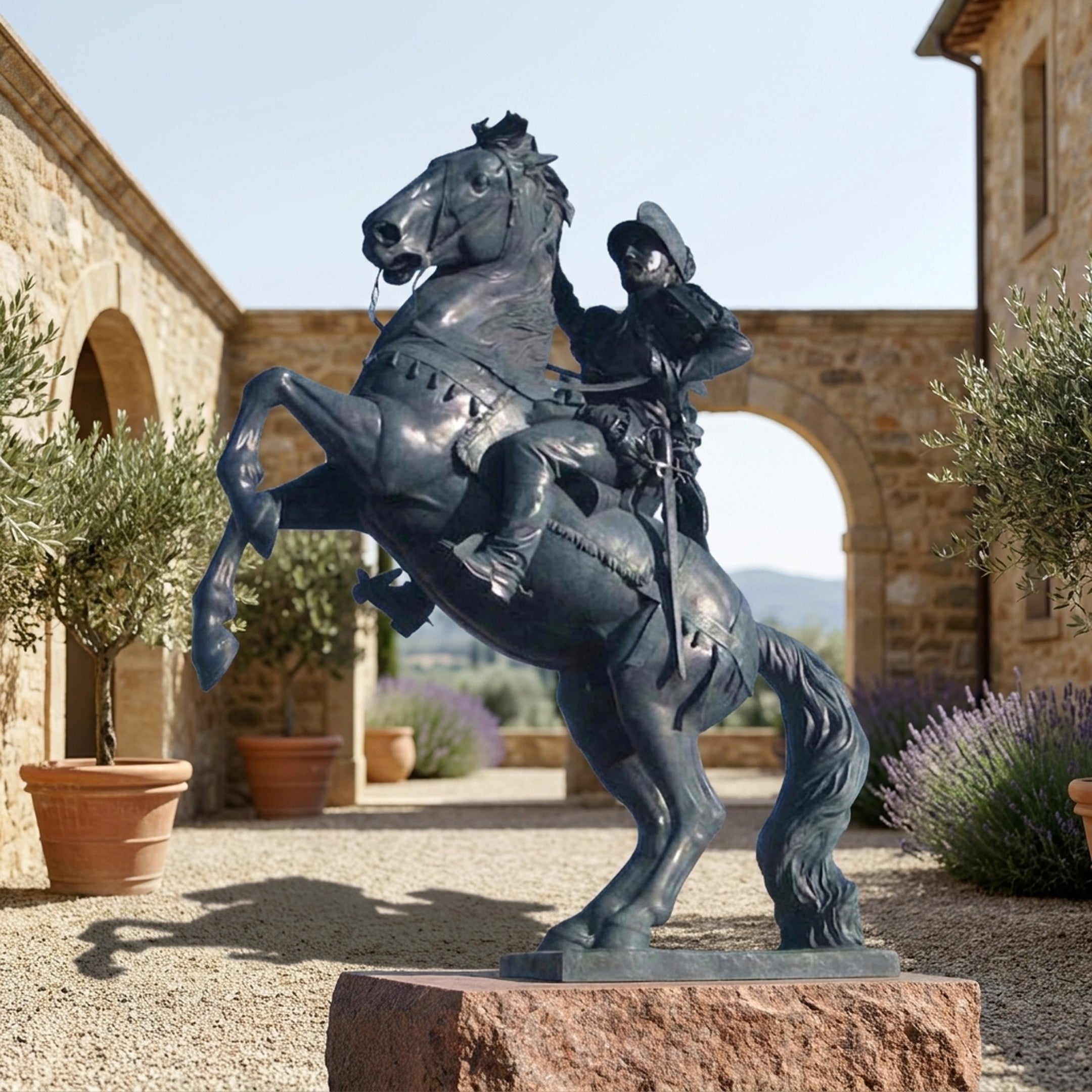 Monumental Mounted Soldier and Rearing Horse Bronze Sculpture by Giant Sculptures with dark patina, on a granite base in a Tuscan courtyard with olive trees.