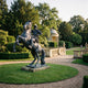 Monumental Traditional Mounted Soldier and Rearing Horse Bronze Sculpture by Giant Sculptures on a granite base in a formal garden with a domed pavilion.