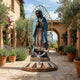 Monumental Traditional Our Lady of Guadalupe Bronze Statue by Giant Sculptures in polychrome blue and brown with gold mandorla, displayed in a Mediterranean courtyard.