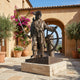Monumental Traditional Pirate Captain Bronze Sculpture by Giant Sculptures, raised cutlass and ship's helm, on a stone plinth in a Tuscan courtyard.
