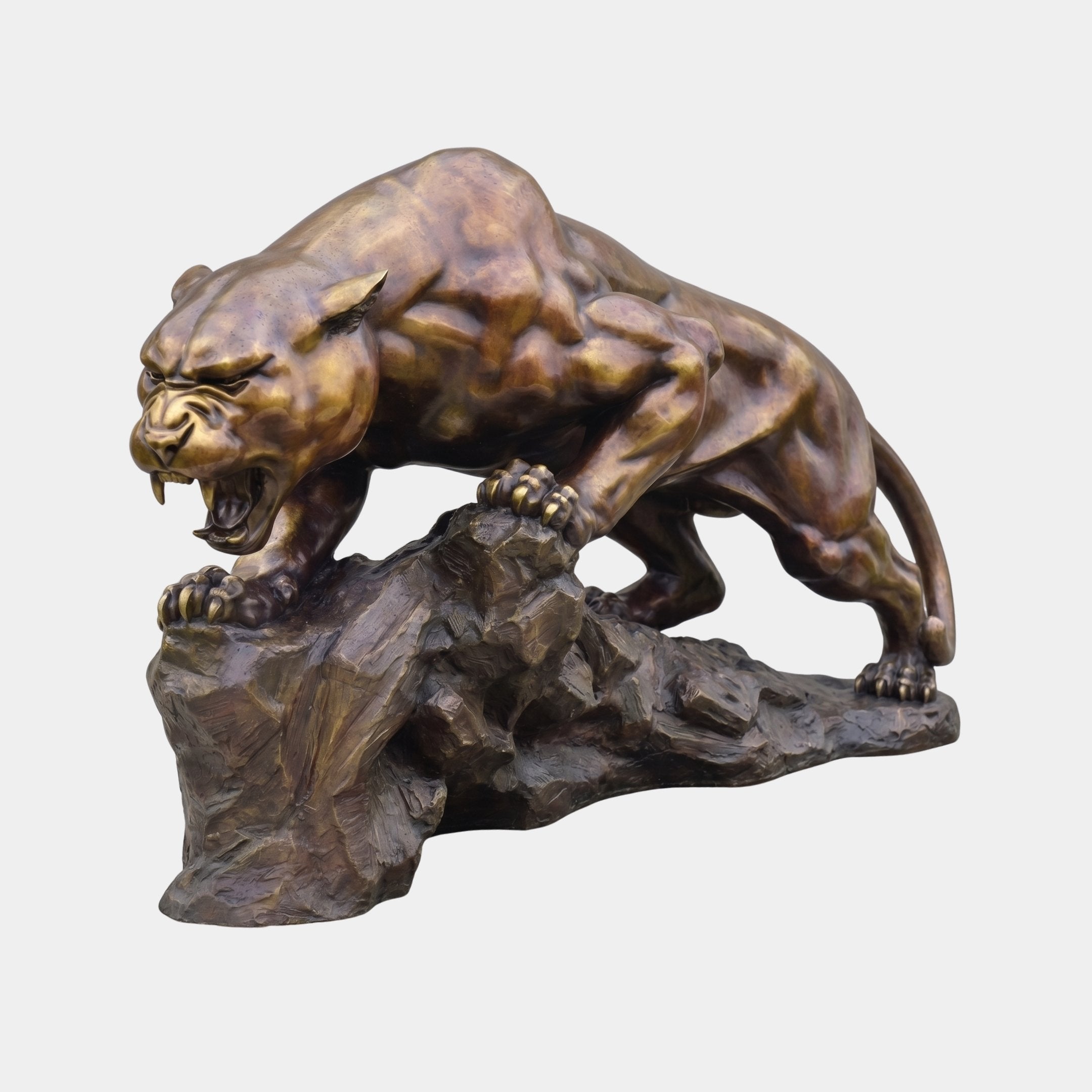 Monumental Traditional Prowling Panther Bronze Sculpture by Giant Sculptures, snarling in a low crouch on a craggy rock base with warm golden-brown patina.