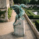 Monumental Traditional Rearing Winged Dragon Bronze Sculpture by Giant Sculptures with verdigris patina, wings spread and jaws open, on a stone plinth in a formal garden.