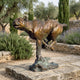 Monumental Traditional Running Cougar Bronze Sculpture by Giant Sculptures in mid-sprint pose with reddish-brown patina, set on a stone courtyard among olive trees.