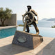 Monumental Traditional Sea Captain Bronze Sculpture by Giant Sculptures, captain gripping a ship's helm on an angled granite plinth beside a poolside sea view.