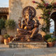 Monumental Traditional Seated Ganesha Bronze Sculpture by Giant Sculptures in padmasana with prabhamandala halo, displayed on a stone plinth in a coastal courtyard.