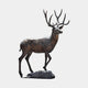 Monumental Traditional Walking Stag Bronze Sculpture by Giant Sculptures shown in side profile with multi-point antlers, dark brown patina, on a rocky base.