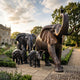 Monumental Trumpeting Elephant Herd Bronze Sculpture by Giant Sculptures, two adults and two calves in dark antique patina, set on a gravel garden path beside lavender borders.