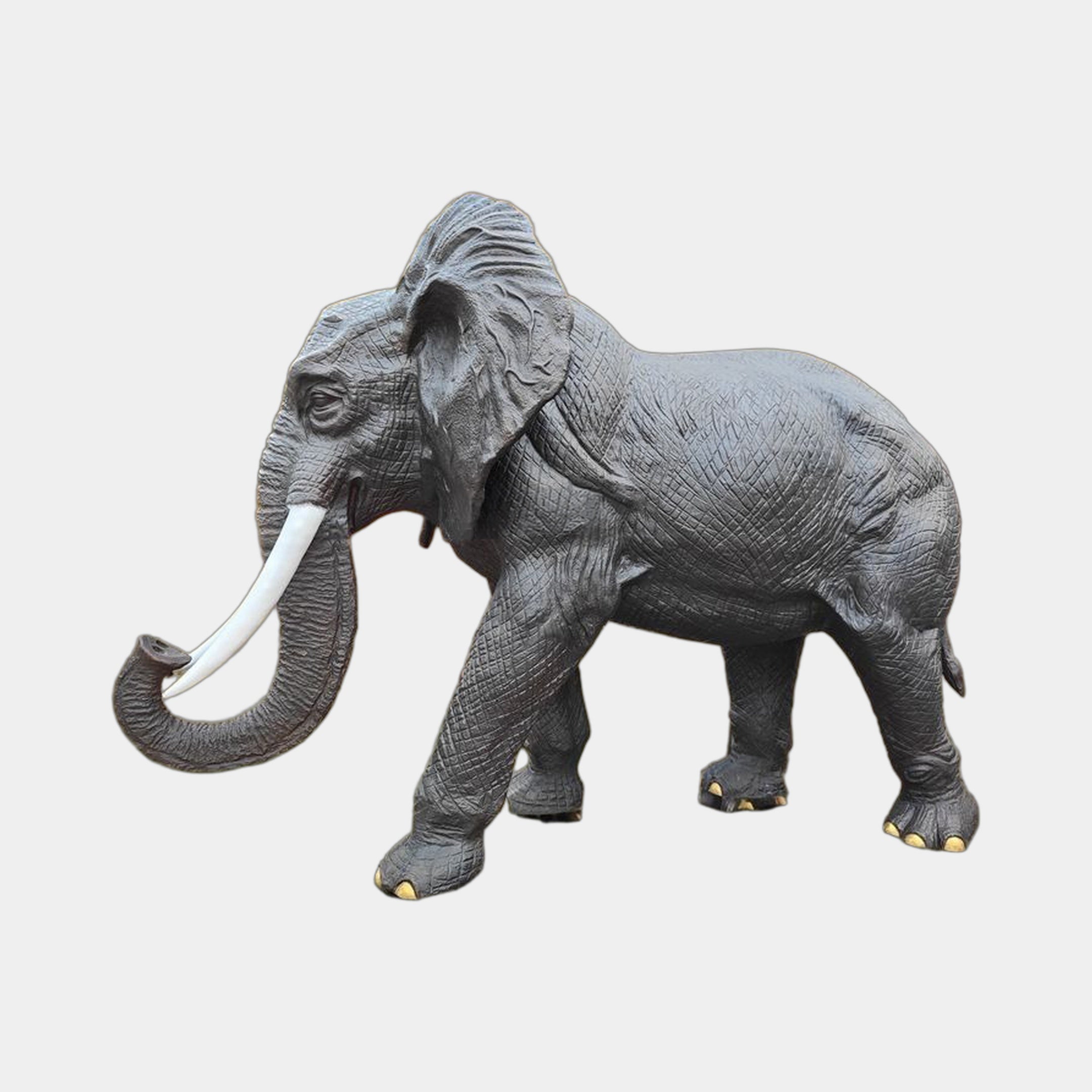 Monumental Walking Elephant Bronze Sculpture by Giant Sculptures, 280cm, shown in side profile with dark patina, white tusks, gold toenails on a plain background.