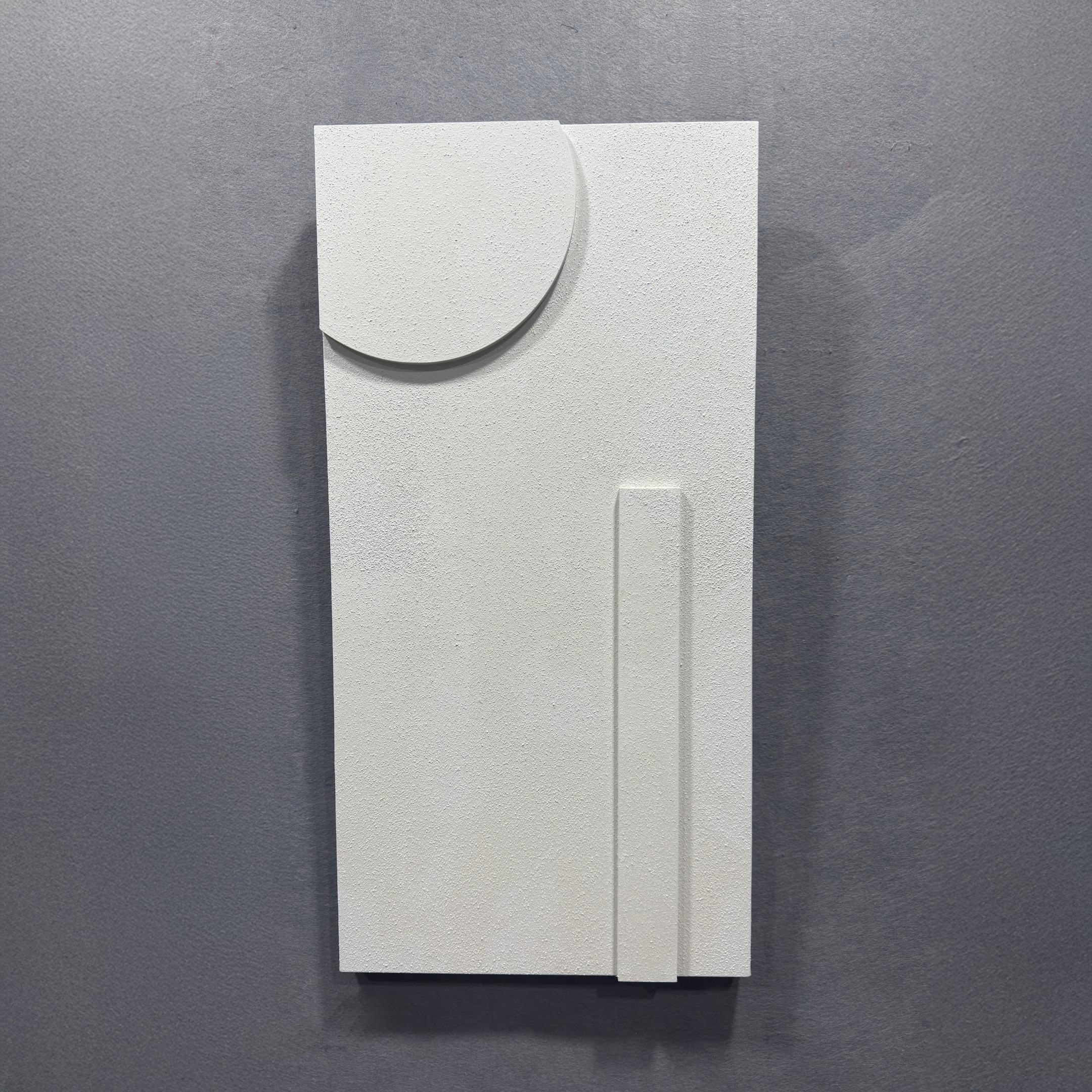 The Moro III Triptych White Relief 3D Wall Art by Giant Sculptures is a minimalist white sculpture with a semicircular shape at the top left and a thin vertical bar at the bottom right, displayed on a gray wall.