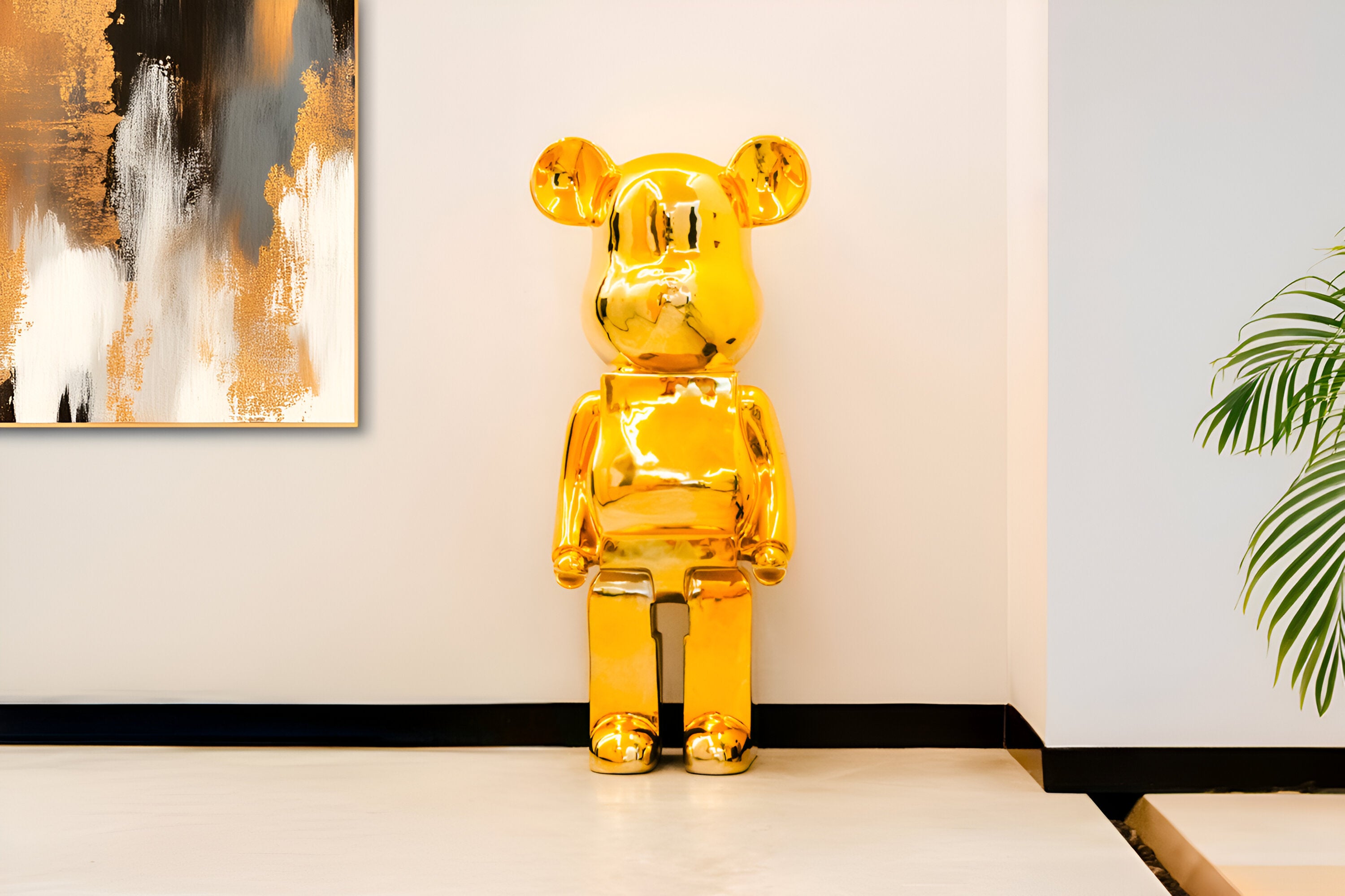 A shiny golden bear sculpture positioned against a light beige wall, reflecting light and blending with the surrounding modern art. A glimpse of a potted green plant adds a touch of nature to the sophisticated interior setting.