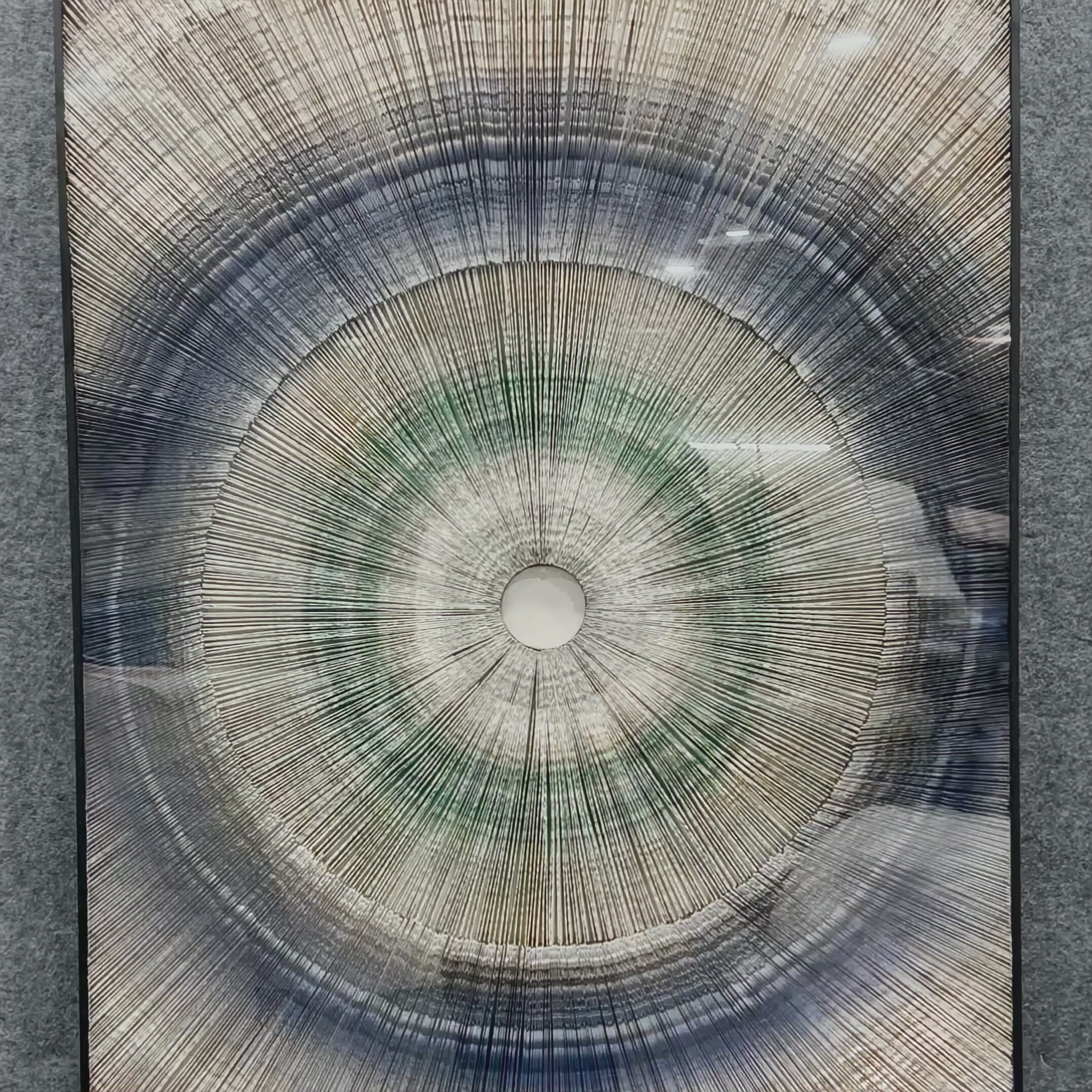 Video of Auralis Blue Gradient Concentric Circular Cardboard Craft Wall Art, showing a layered circular design with radiating lines in soft gradients of blue, green, and beige, forming an abstract concentric ripple effect.