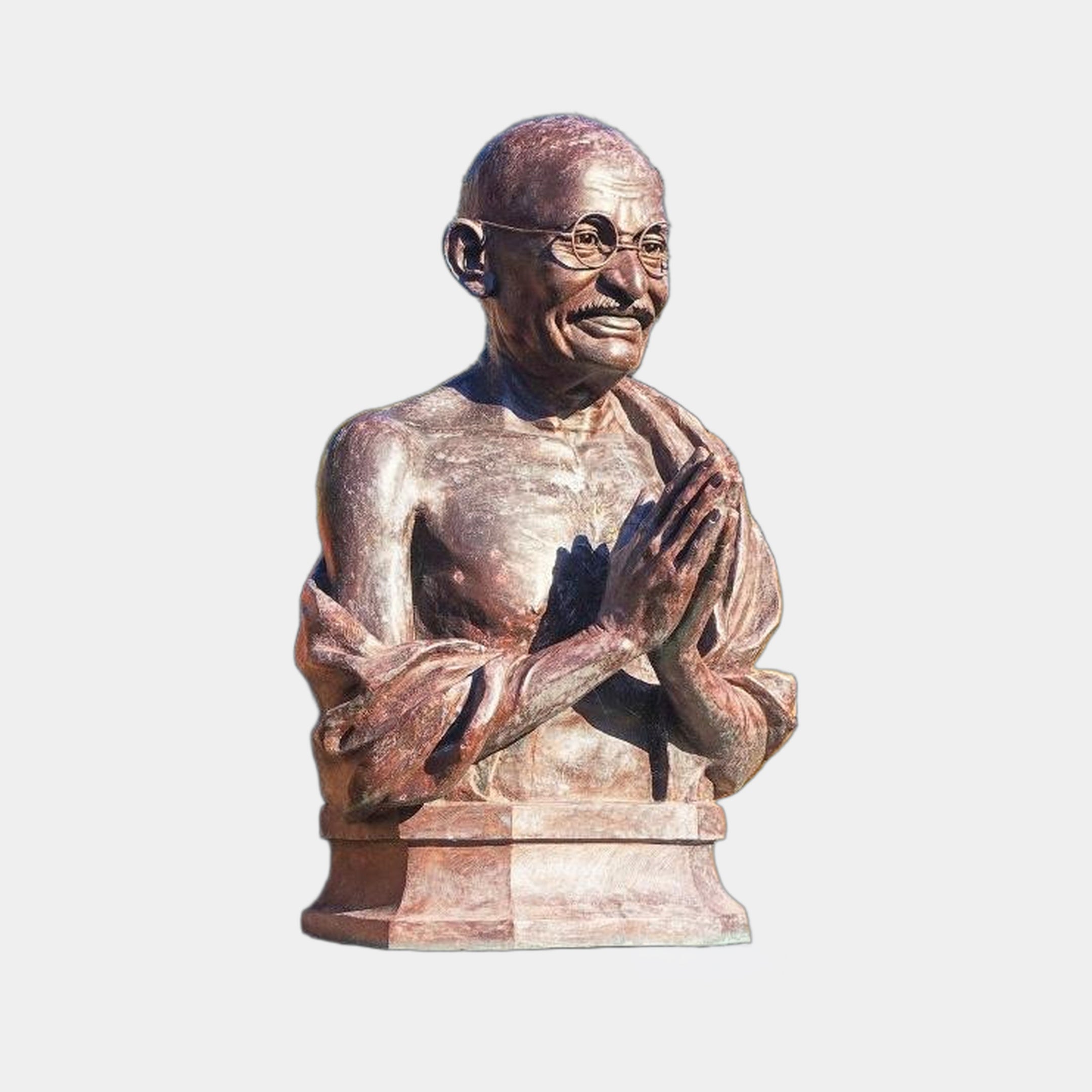 Giant Sculptures Traditional Bespectacled Elder Bust in reddish-brown cast bronze, hands in namaste, on a two-tiered stone plinth against a light grey background.