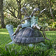 Giant Sculptures Traditional Children on Tortoise Bronze Sculpture 140cm, two girls seated back-to-back with arms raised on a spiral-shelled tortoise in a garden.