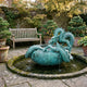Giant Sculptures' 90cm Traditional Chinese Dragon and Fish Vessel Bronze Sculpture in verdigris patina, set in a mossy stone pond fountain beside a wooden garden bench.
