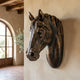Traditional Horse Head Bronze Relief 80cm by Giant Sculptures, mounted on a rustic plaster wall with dark mane detail, beside an arched window and olive branches.
