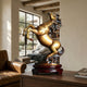 Traditional Rearing Horse Bronze Sculpture by Giant Sculptures on a lacquered wooden stand, displayed on a sideboard in a warm interior with leather armchair.