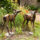 Traditional Standing Fawn Pair Bronze Sculpture by Giant Sculptures, two 90cm spotted deer with warm patina, shown in a garden among wildflowers.